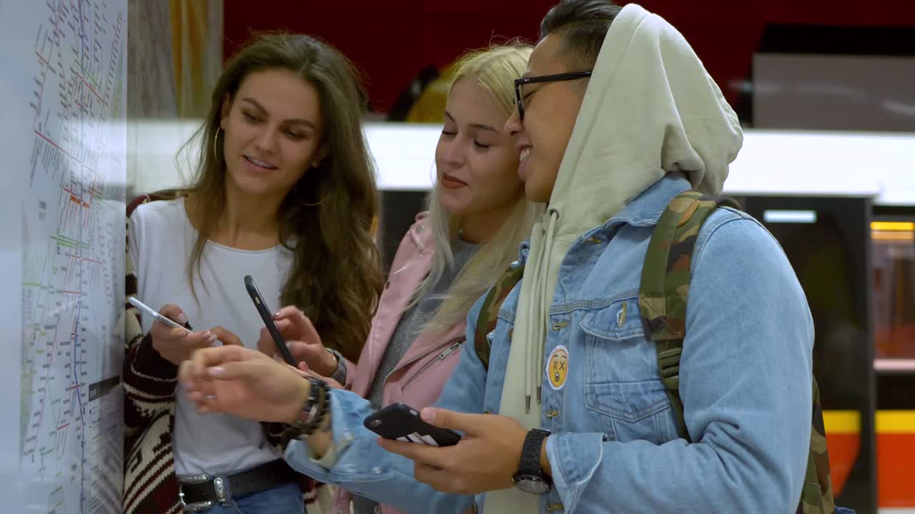 друзья анализируют карту в метро.