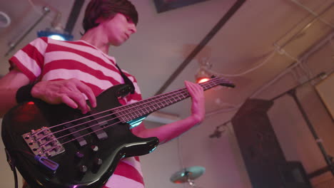 boy playing guitar during a band rehearsal in recording studio