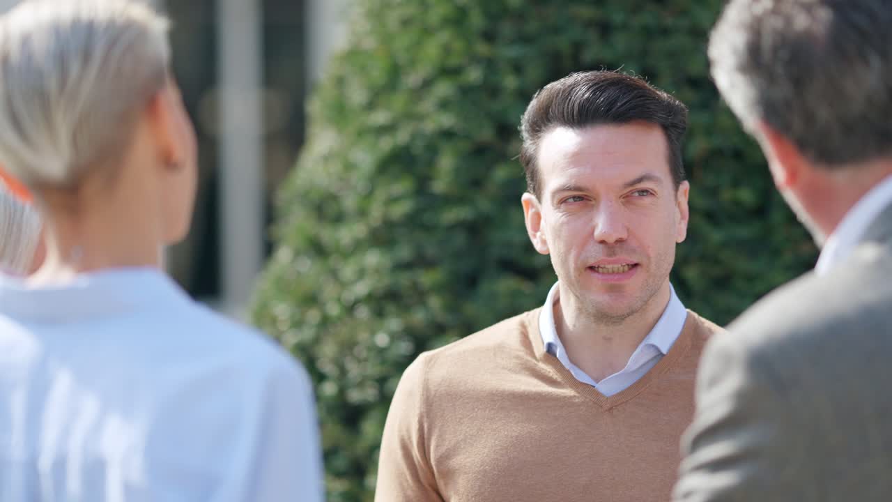Three People Engaged in an Outdoor Conversation