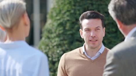 three people engaged in an outdoor conversation