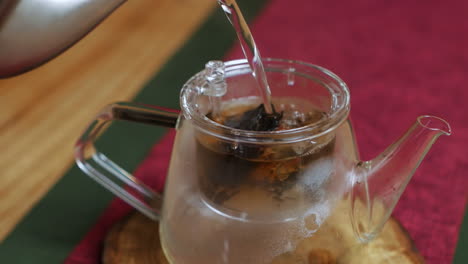 preparar té en una tetera de vidrio