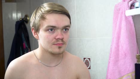 young man combing his hair in the bathroom