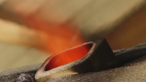 a large, intense flame is visible burning within a furnace, seen through a narrow slit