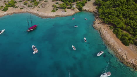 Aufsteigende-Drohnenaufnahme-Von-Festgemachten-Yachten-Und-Katamaranen-In-Einer-Wunderschönen-Bucht-Zum-Tauchen