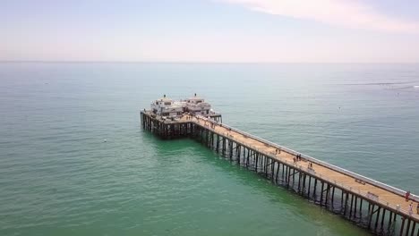 Caminata-De-Fin-De-Semana-En-El-Muelle-De-Pesca-Deportiva-De-Malibu-Vista-Aérea-Suave-Y-Mantecosa-Vuelo-Que-Se-Eleva-Lentamente-Imágenes-De-Drones-En-La-Playa-Del-Muelle-De-Malibu-Estados-Unidos-2018