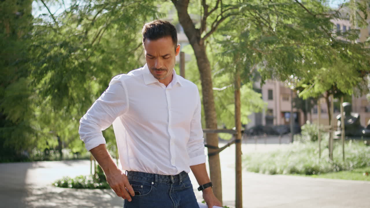 Man strolling sunny alley district closeup. Architect picking up phone