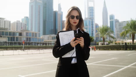 elegant businesswoman with phone outdoors