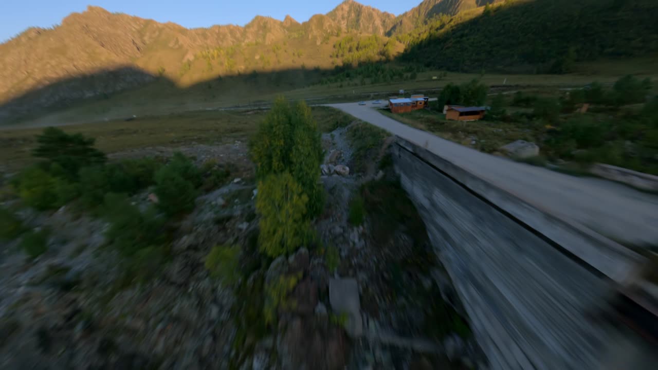 vista aérea puente volador sobre río de montaña natural con personas que caminan y automóviles de campamento