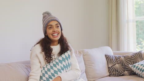 happy woman in warm clothing sitting on sofa watching television 4k 4k