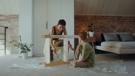 mother and son painting furniture together