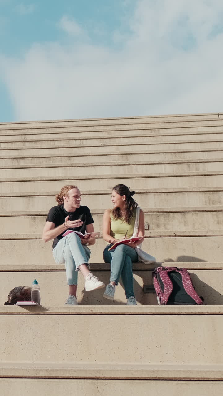 Girl and boy students talking, doing homework, preparing for exams sitting on