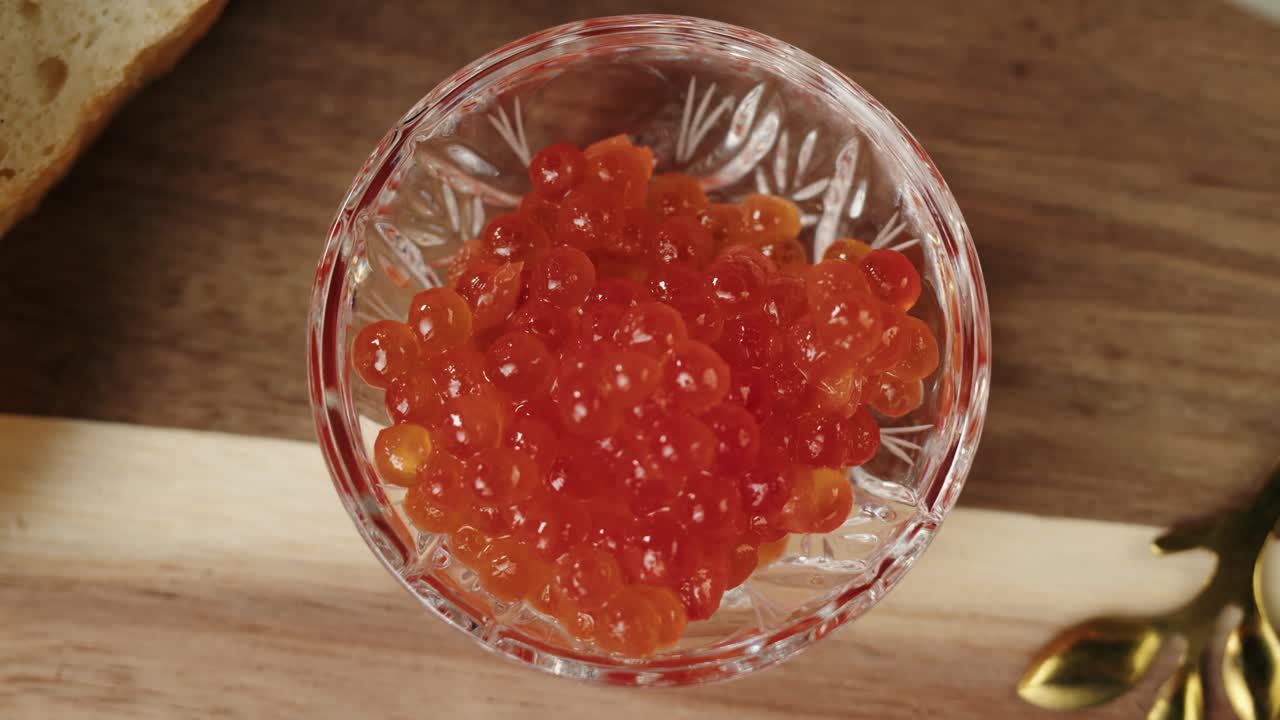 Caviale rosso prelevato da una ciotola di cristallo.
