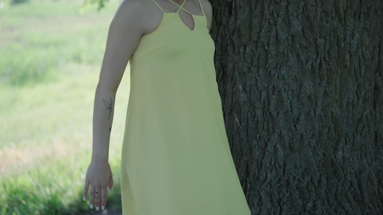 счастливая красивая молодая девушка танцует свободу в летнем парке с деревьями на заднем плане.