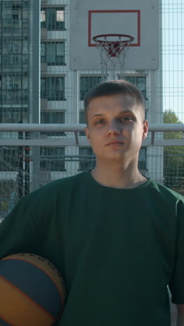 young man playing basketball outside