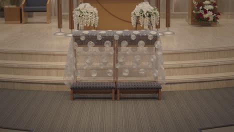 decorated wooden bench for bride and groom at their catholic church wedding