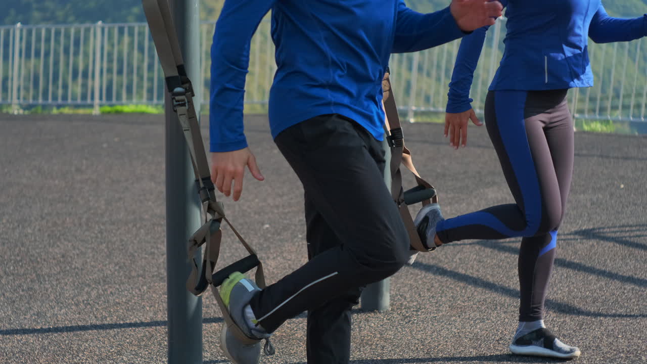 커플이 야외에서 서스펜션 훈련을 하고 있습니다.