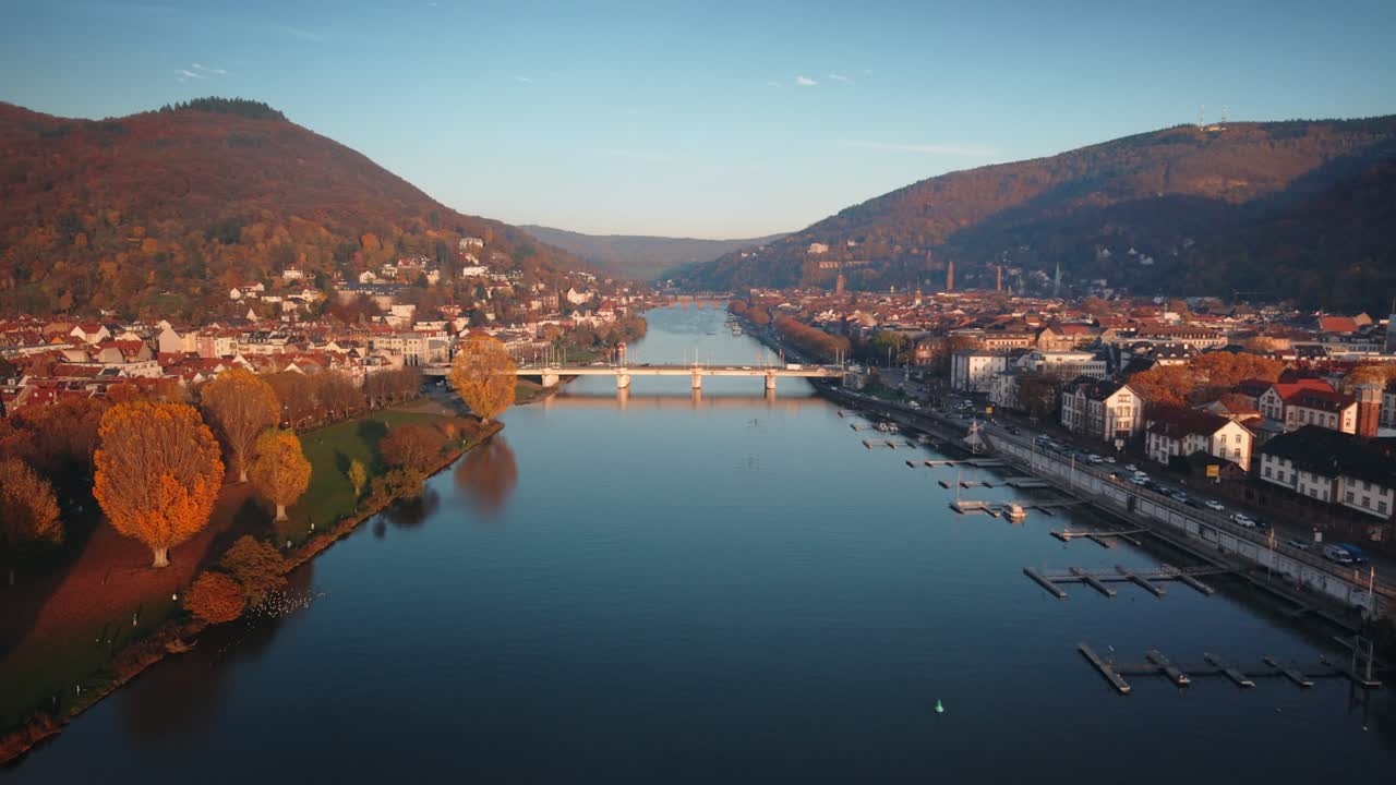 Malerisk dronefoto af Theodor-Heuss-broen over Neckar-floden i Heidelberg under gyldent efterårslys