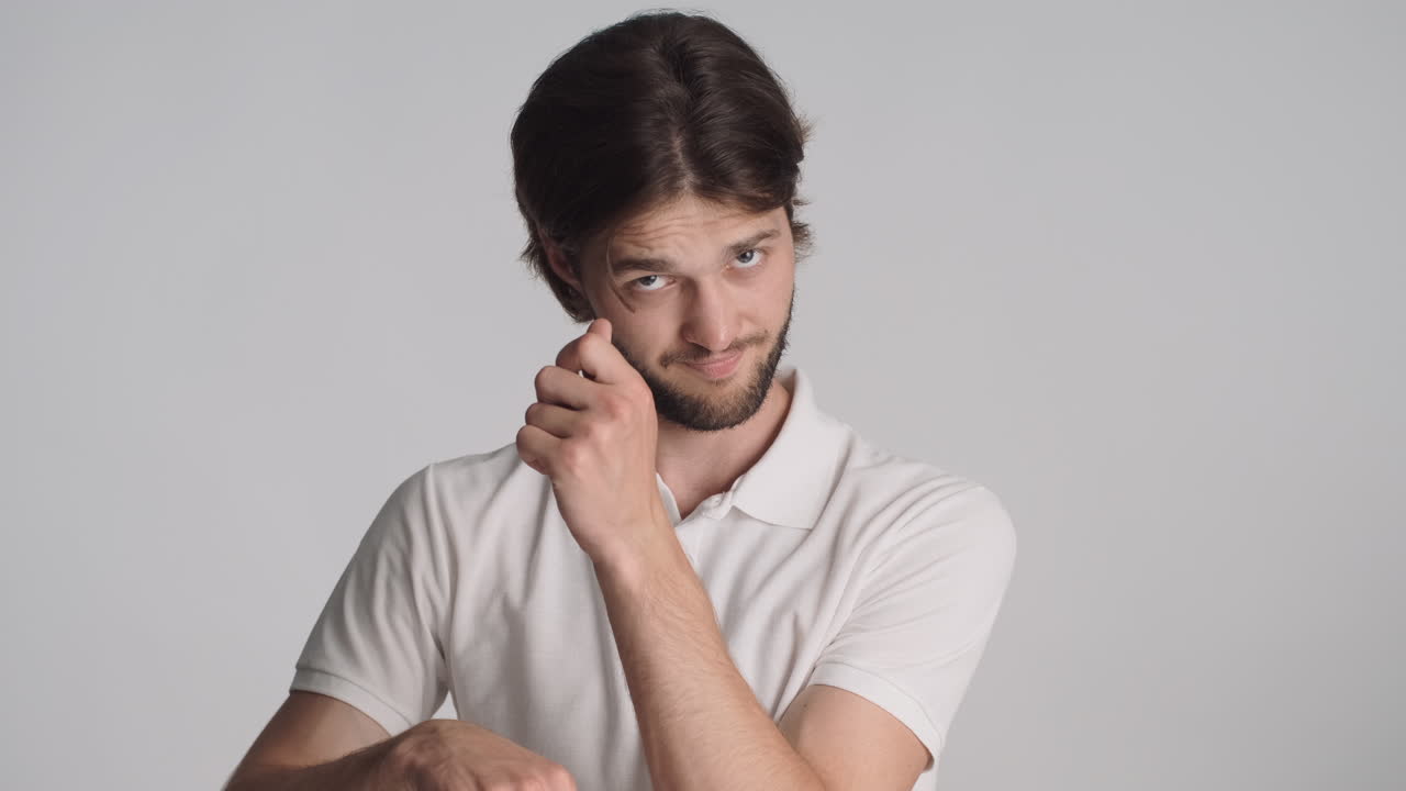 hombre caucásico frente a la cámara sobre un fondo gris.