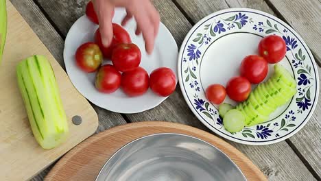 slicing cucumber with tomatoes on a cutting board for salad dish stock footage