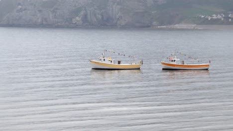 Paar-Touristenboote,-Die-Sich-Vor-Der-Küste-Unter-Dem-Nebligen-Walisischen-Inselufer-Vorbereiten