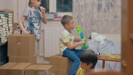 grupo de niños jugando entre cajas en casa