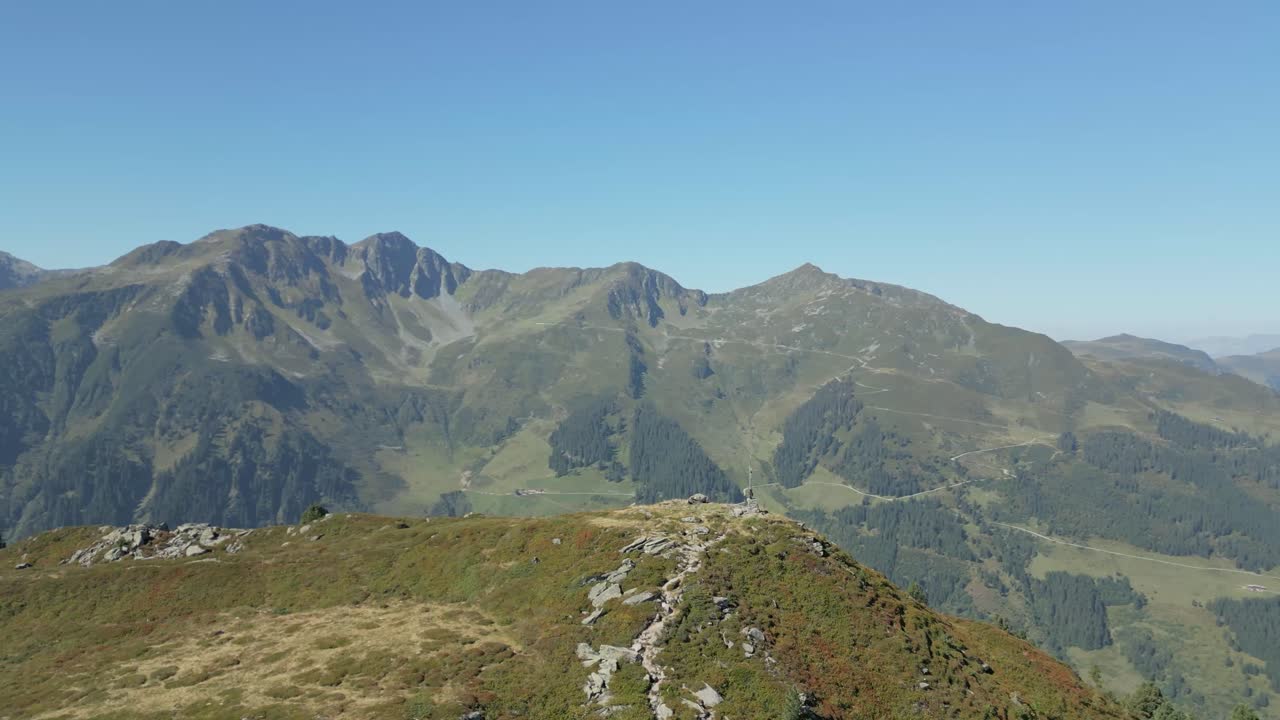 avión no tripulado volando alrededor de la cruz en el pico de la montaña con cielos azules y clima perfecto en verano hermosa vista en el tirol austria