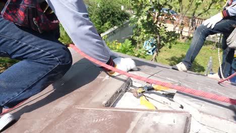 asian worker doing roof installation on site, close up