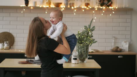 Joven-Madre-Sosteniendo-A-Su-Hijo-Recién-Nacido-A-Cámara-Lenta.-Familia-En-Casa,-Mamá-Y-Bebé,-Para-Navidad