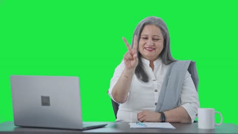 Happy-Indian-senior-businesswoman-showing-victory-sign-Green-screen