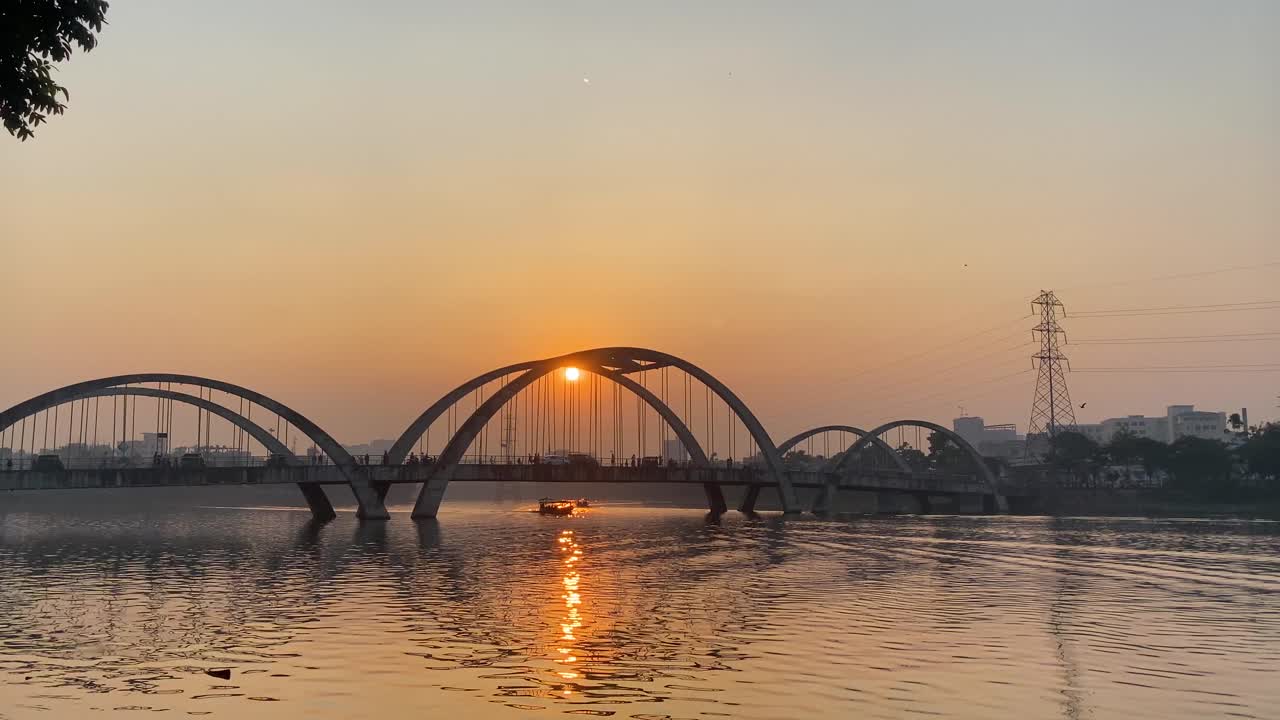 vista de un movimiento de tráfico en un puente sobre un río con una hermosa puesta de sol en el fondo en dhaka, bangladesh