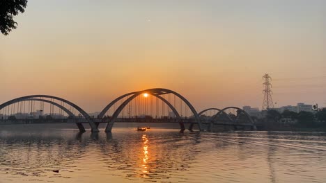 Blick-Auf-Eine-Verkehrsbewegung-Auf-Einer-Brücke-über-Einen-Fluss-Mit-Einer-Wunderschönen-Untergehenden-Sonne-Im-Hintergrund-In-Dhaka,-Bangladesch