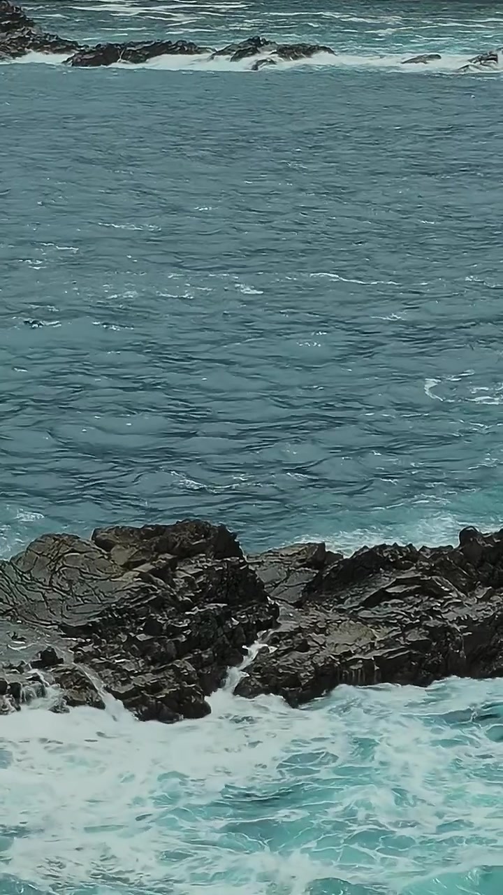Ombak menerjang bebatuan di Tenerife, Spanyol saat hari di tepi pantai