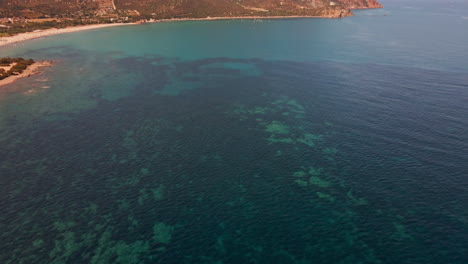 panorama on the blue sea with beach and mediterranean mountains in background during summer in italy - aerial drone shot