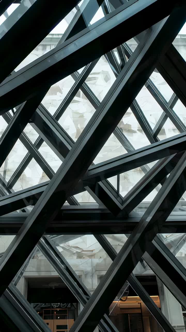 Vertical video: Starting camera panning, revealing atrium wall and lit doorway behind steel lattice
