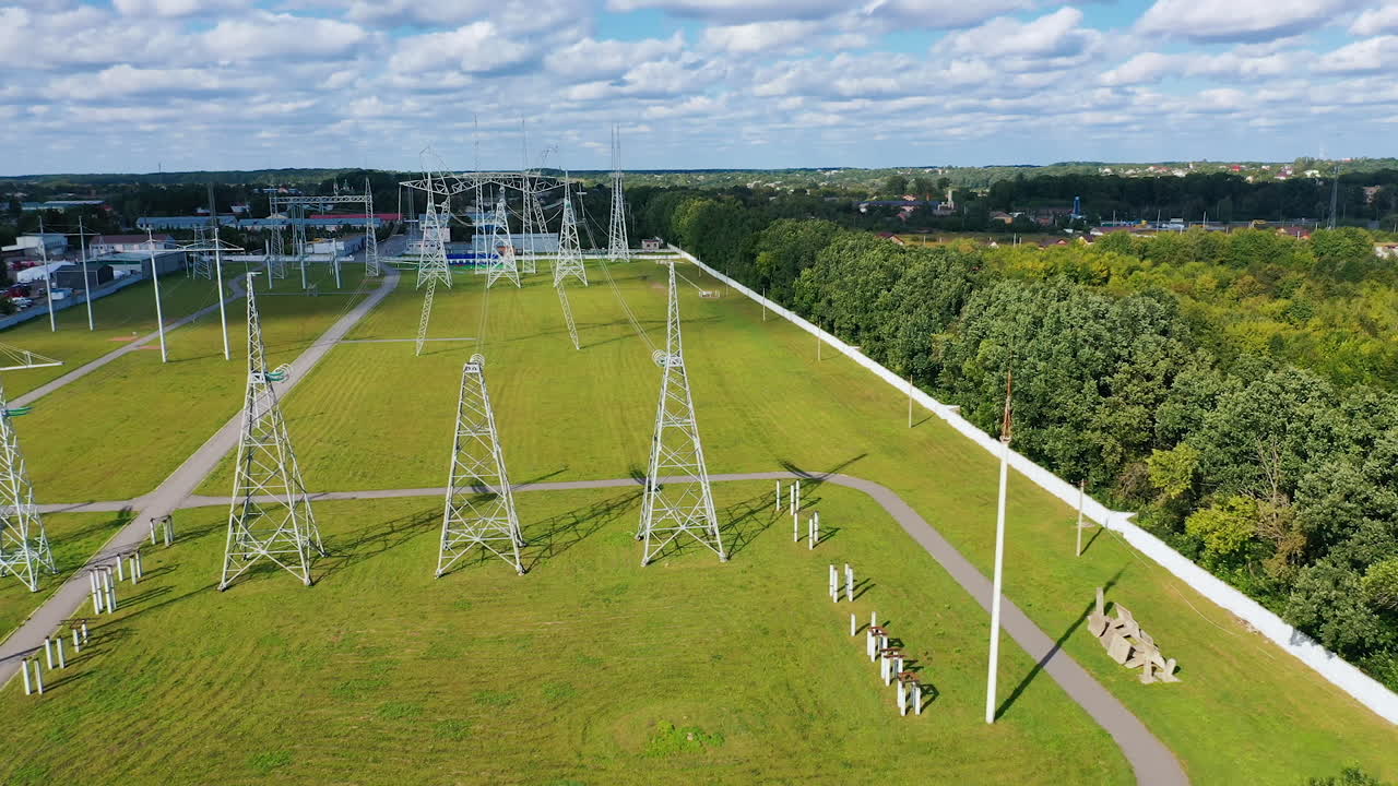 Panoramic view on a field with electric towers. High- voltage power lines with wires on the background of green nature in rural place.