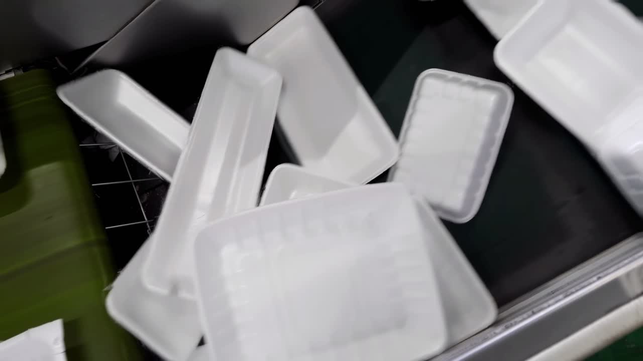 Slow motion the foam boxes are falling down to the belt.