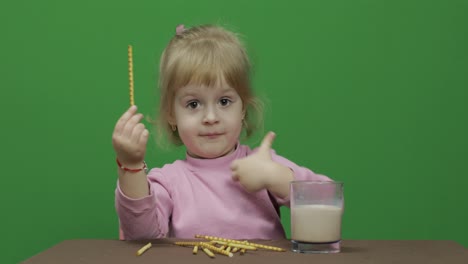 The-child-eats-cookies.-A-little-girl-is-eating-cookies-sitting-on-the-table.