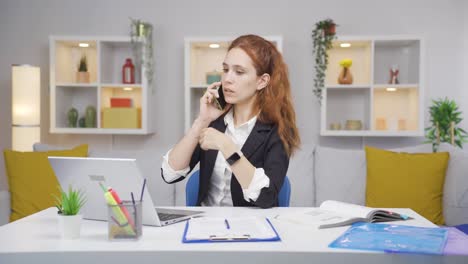 Una-Trabajadora-De-Oficina-En-Casa-Habla-Por-Teléfono-Con-Calificaciones-Femeninas.