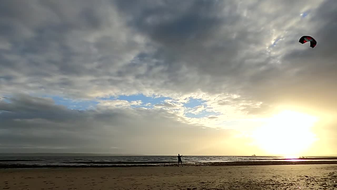 파워 카이트를 제어하고 아름다운 일몰을 배경으로 8개의 큰 숫자로 연을 급습합니다.
