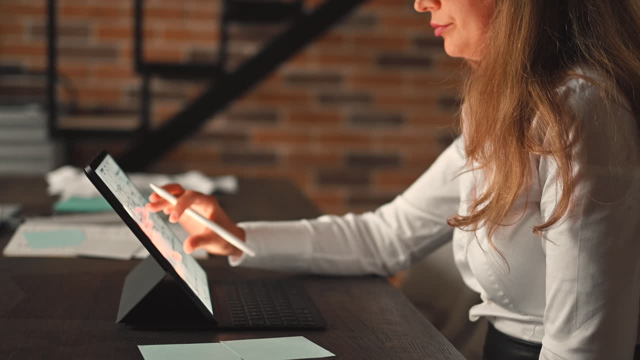 Woman working on a tablet with a stylus pen at an office