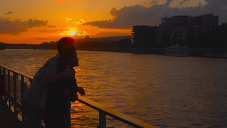 Couple-embracing-enjoying-sunset-on-a-terrace-at-Danube,-Bratislava