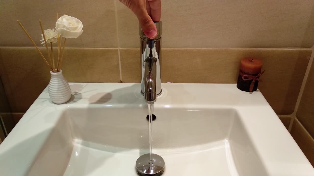 agua corriente del lavabo blanco del baño de lujo en la habitación del hotel
