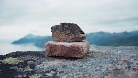 apilando rocas en las montañas kvaenan en noruega, con vistas al paisaje