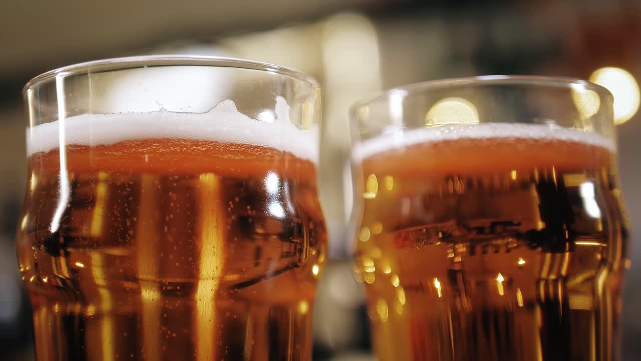 Due bicchieri di birra dorata con schiuma e bollicine
