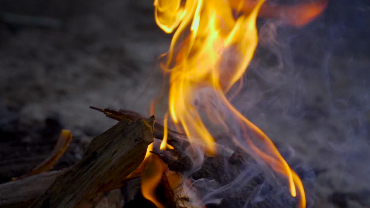 primer plano en cámara lenta de una fogata por la noche, capturando llamas y humo