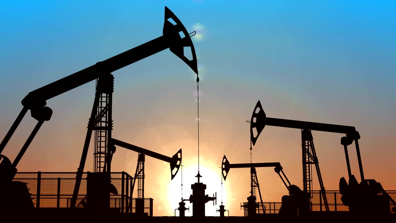 bombas de aceite en bucle contra el cielo azul del atardecer