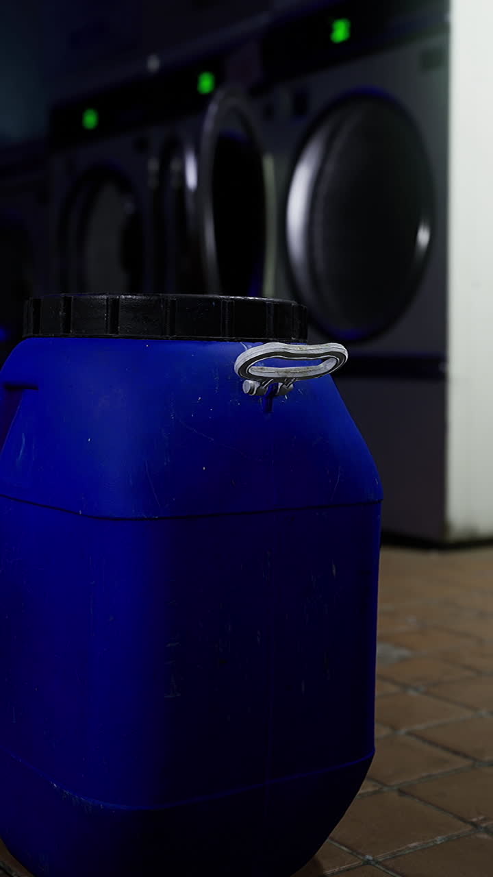 Blue container placed in a laundromat with washing machines in the background