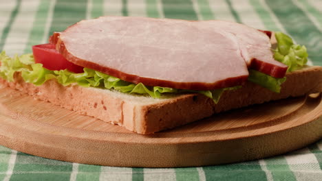 ham and vegetable sandwich on wooden board