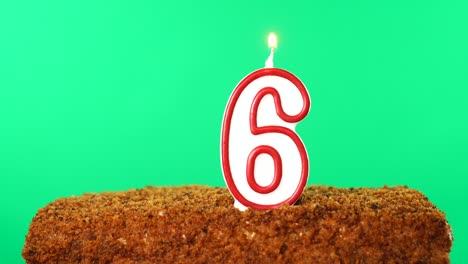 cake with the number 6 lighted candle. chroma key. green screen. isolated