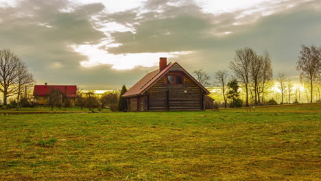 Wooden-Cottage-In-Rural-Landscape-During-Golden-Sunrise